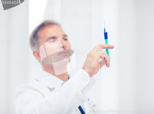 Image of male doctor holding syringe with injection