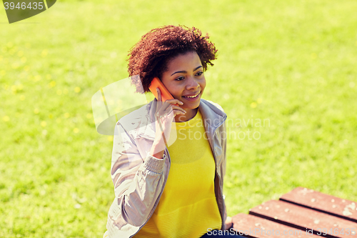 Image of smiling african young woman calling on smartphone