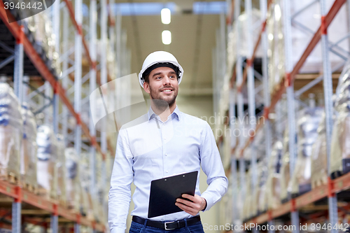 Image of happy businessman with clipboard at warehouse