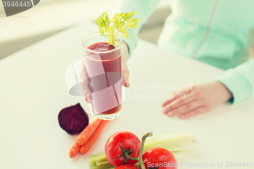 Image of close up of woman hands with juice and vegetables