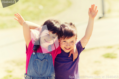 Image of two happy kids hugging outdoors