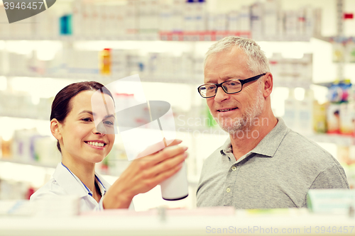 Image of pharmacist showing drug to senior man at pharmacy