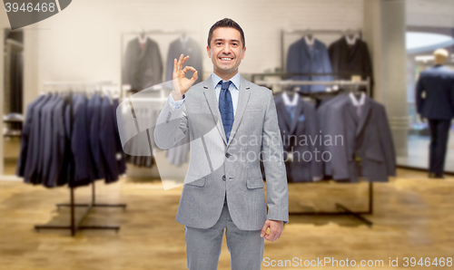 Image of happy businessman in suit over clothing store