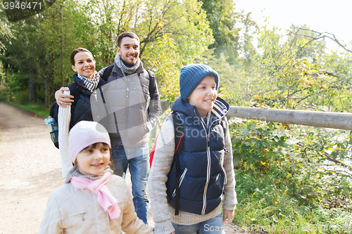 Image of happy family with backpacks hiking in woods