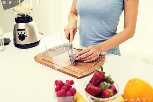 Image of close up of woman chopping strawberry at home