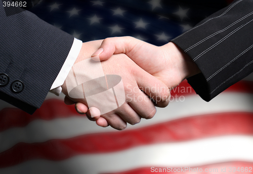 Image of hand shake and a American flag in the background