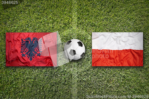 Image of Albania vs. Poland flags on soccer field