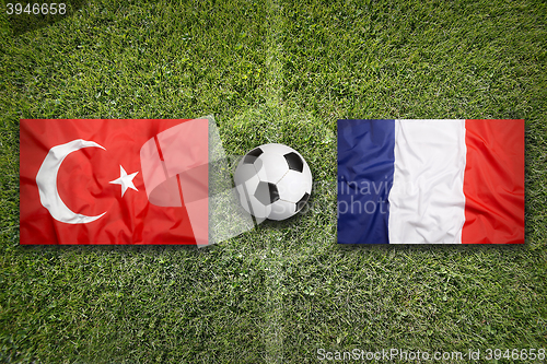 Image of Turkey vs. France flags on soccer field