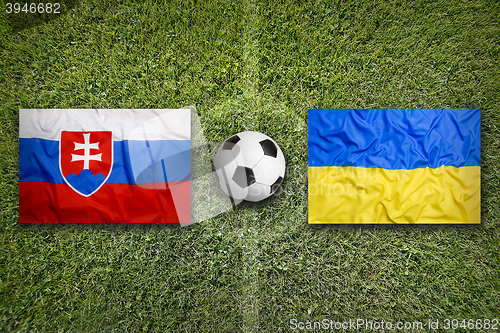 Image of Slovakia vs. Ukraine flags on soccer field