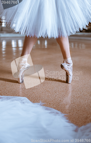 Image of The close-up feet of young ballerina in pointe shoes