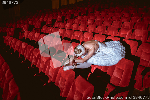 Image of Ballerina sitting in the empty auditorium theater