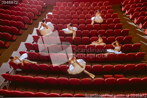 Image of Ballerinas sitting in the empty auditorium theater