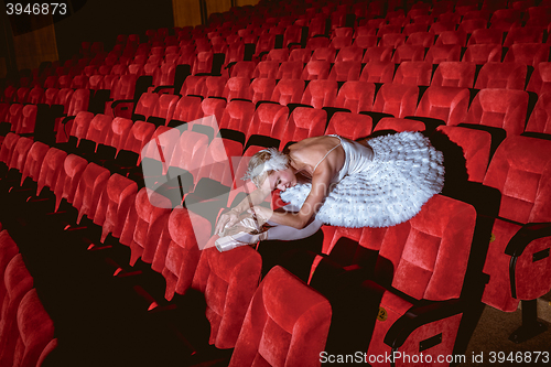 Image of Ballerina sitting in the empty auditorium theater