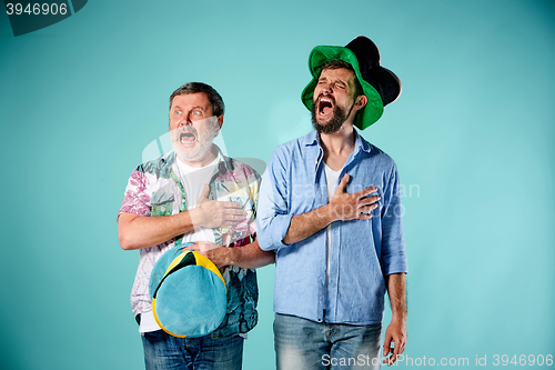 Image of The two football fans singing the national anthem over blue