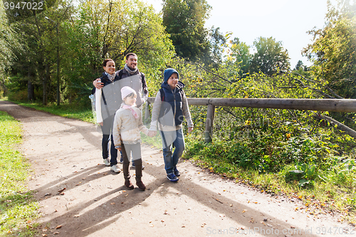 Image of happy family with backpacks hiking in woods