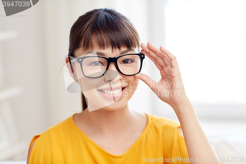 Image of happy asian young woman in glasses at home