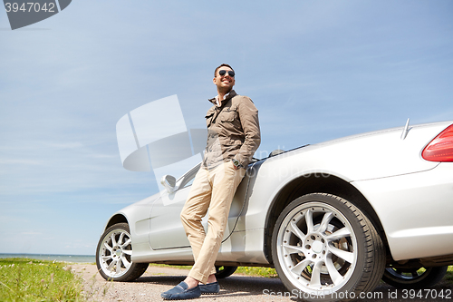 Image of happy man near cabriolet car outdoors