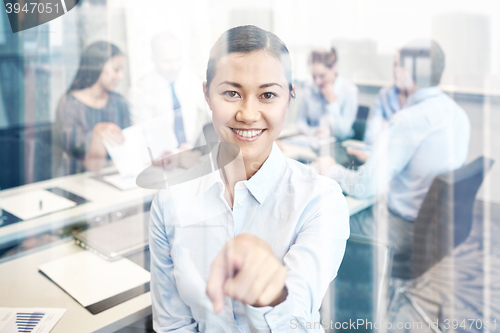 Image of group of smiling businesspeople meeting in office