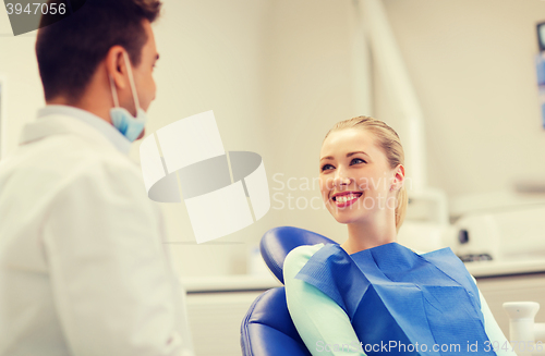 Image of happy male dentist with woman patient at clinic