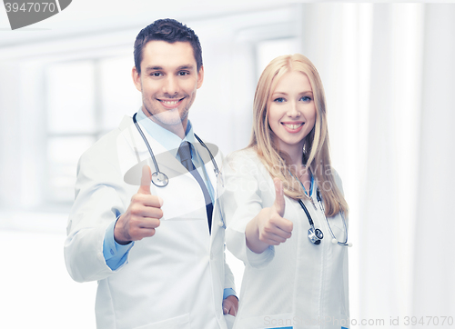 Image of young team of two doctors showing thumbs up