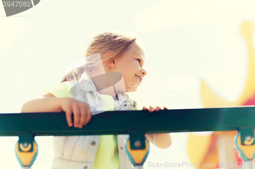 Image of happy little girl climbing on children playground