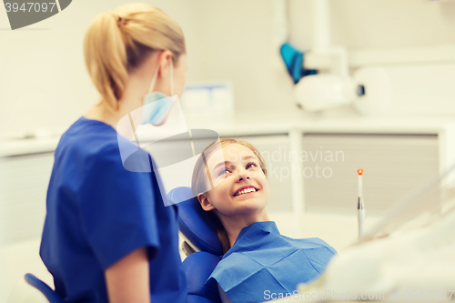 Image of happy female dentist with patient girl at clinic