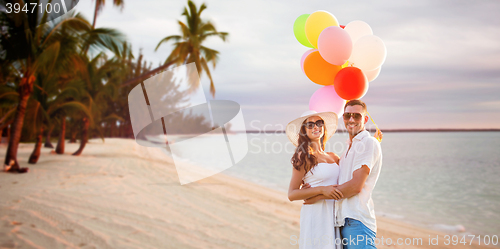 Image of smiling couple with air balloons outdoors