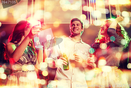 Image of smiling friends with wine glasses and beer in club