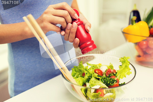 Image of close up of woman cooking vegetable salad at home