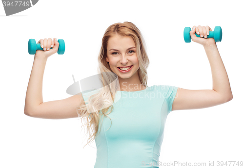 Image of smiling beautiful young sporty woman with dumbbell