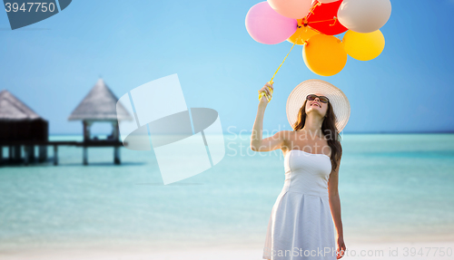 Image of smiling young woman in sunglasses with balloons