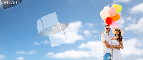 Image of smiling couple with air balloons outdoors