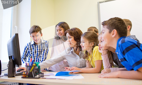 Image of group of kids with teacher and computer at school