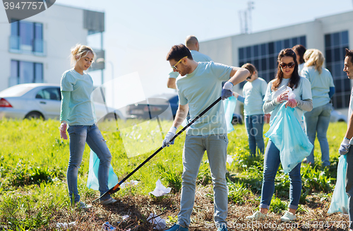 Image of volunteers with garbage bags cleaning park area