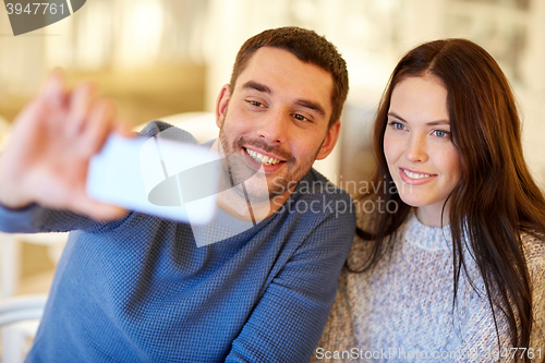 Image of couple taking smartphone selfie at cafe restaurant