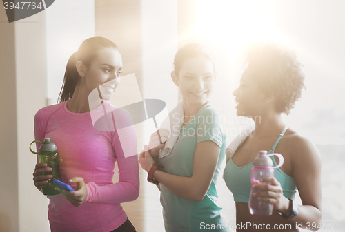 Image of happy women with bottles of water in gym