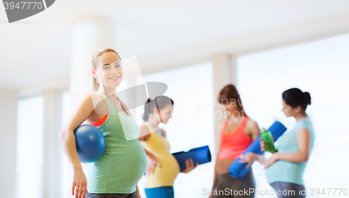 Image of happy pregnant woman with ball in gym