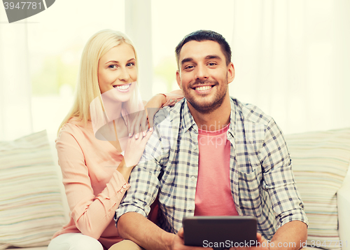 Image of smiling happy couple with tablet pc at home