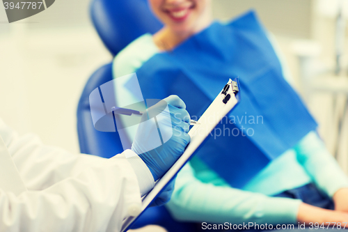 Image of close up of dentist with clipboard and patient