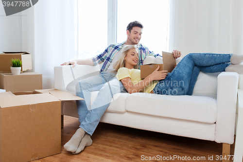 Image of happy couple with big cardboard boxes at new home