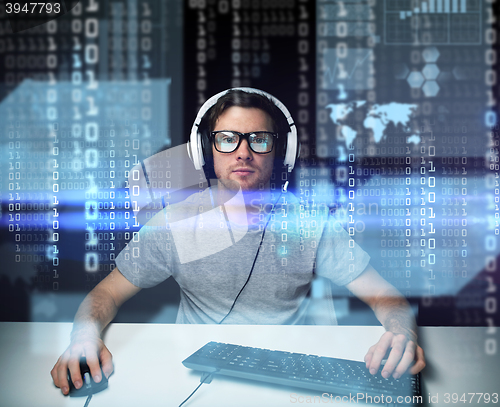 Image of man in headset hacking computer or programming