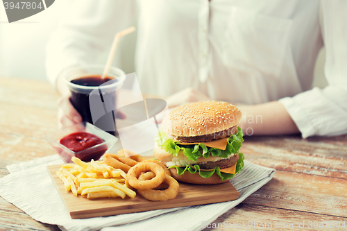 Image of close up of woman with fast food and cola