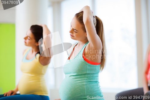Image of happy pregnant women exercising in gym