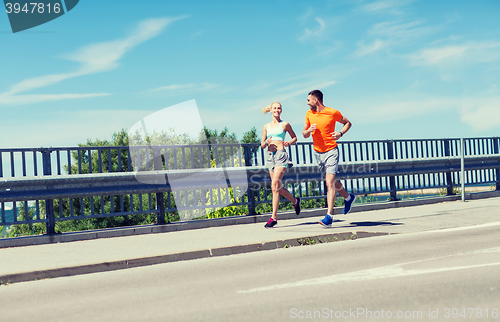 Image of smiling couple running at summer seaside