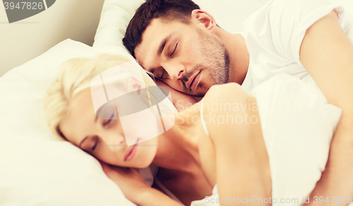 Image of happy couple sleeping in bed at home