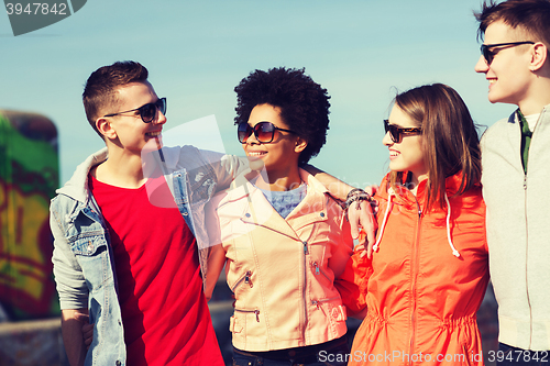 Image of happy teenage friends in shades talking on street