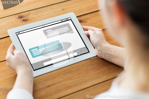 Image of close up of woman with tablet pc on wooden table