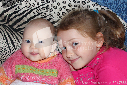 Image of two little babies sisters lying on the bed