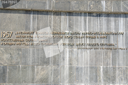 Image of Moscow, Russia - August 10, 2015: The inscription with the TASS report on the withdrawal of artificial earth satellite at the foot of the monument \"Conquerors of Space\" in Moscow