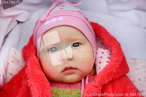 Image of little baby with sad sight in the perambulator